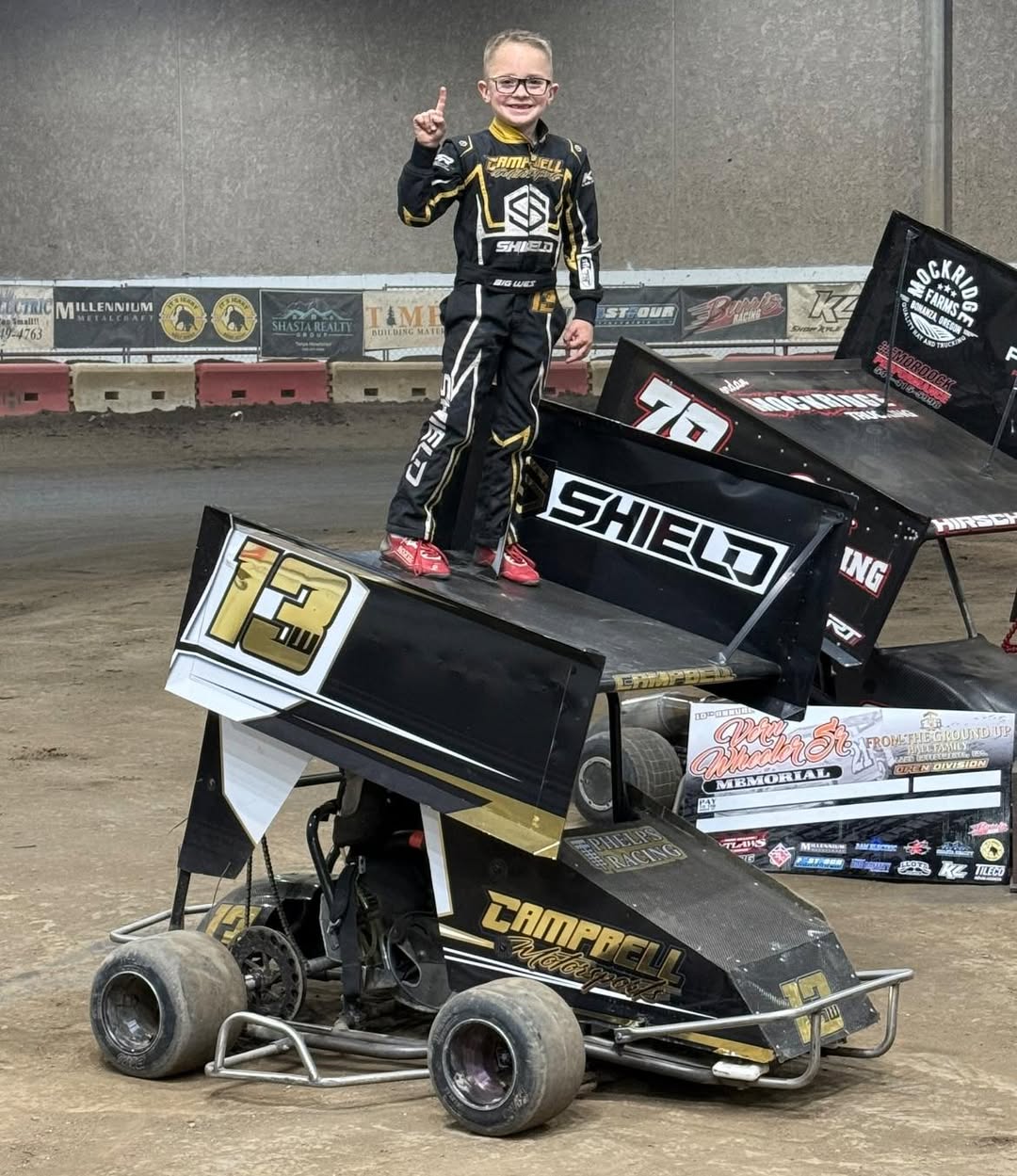 Youth driver standing on winged sprint car